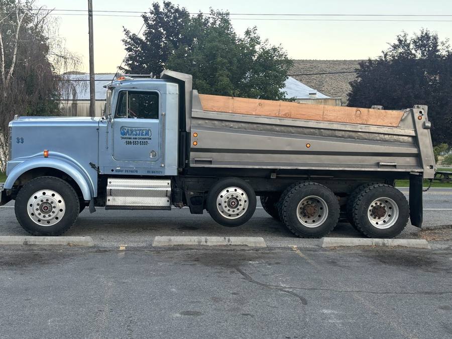 A Sarsten dump truck with wood sideboards, loaded and parked in Omak